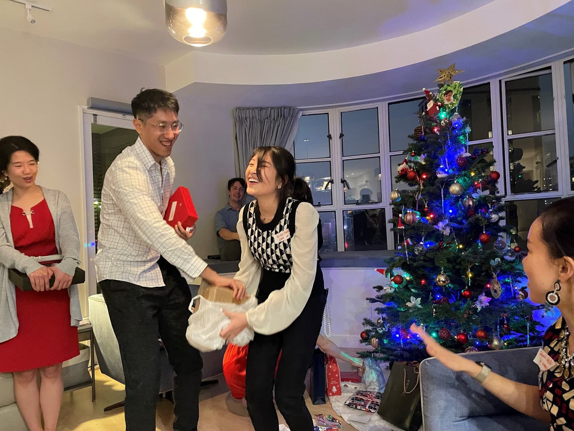 Members laughing during the gift exchange at the Yale Club of Hong Kong Christmas party