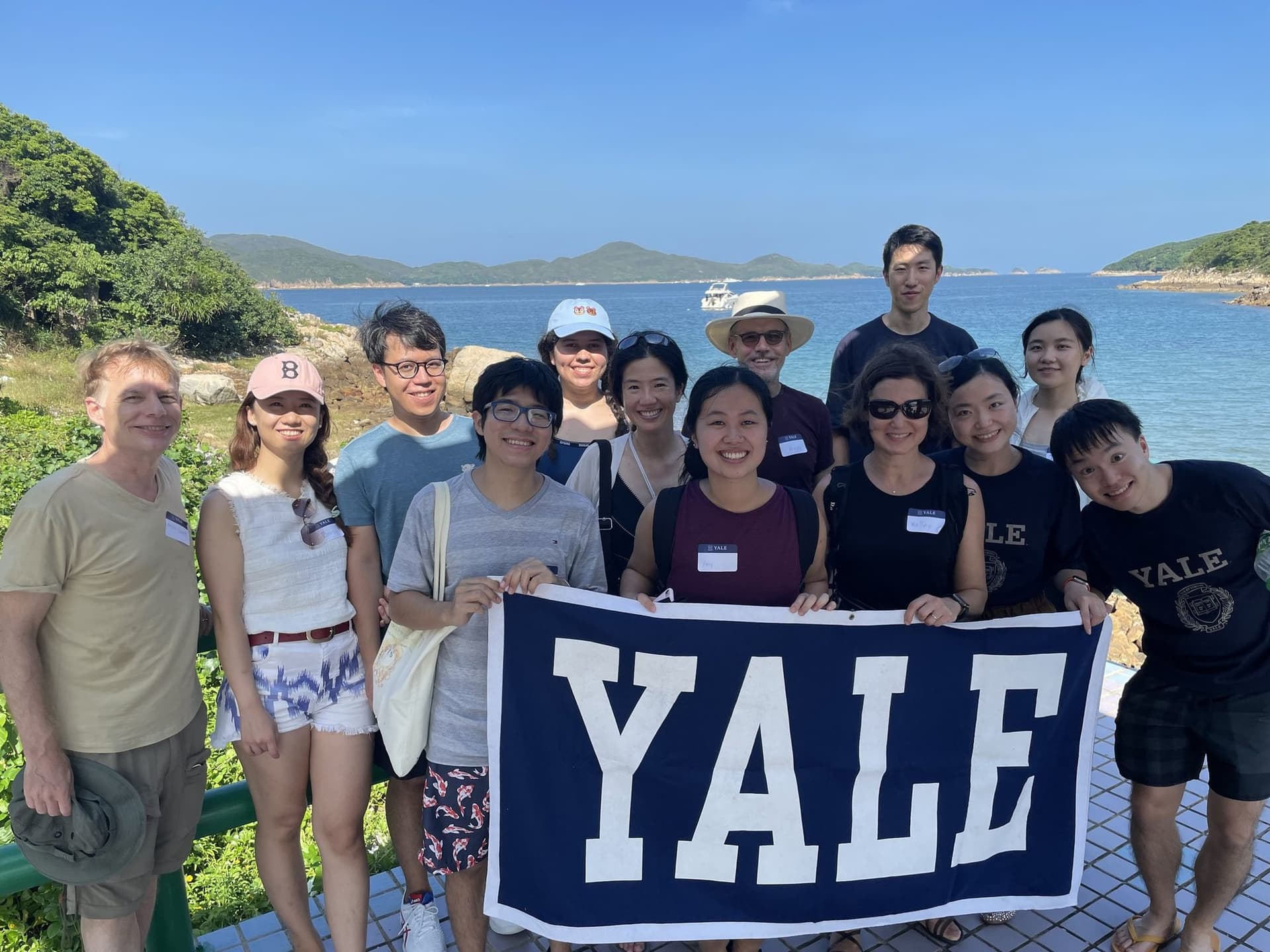 Club members holding a Yale banner on a boat tour of the UNESCO Global Geopark