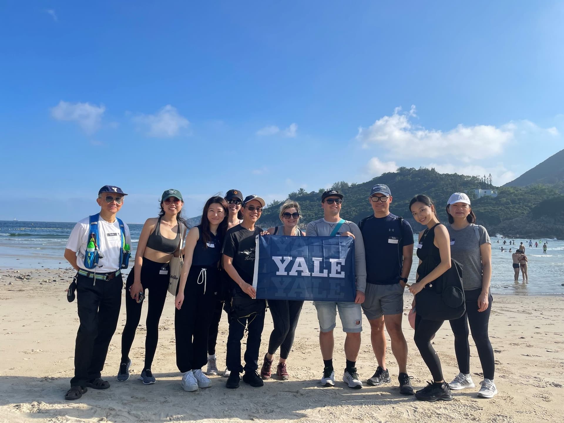 Hikers with a Yale banner on the sand at Big Wave Bay