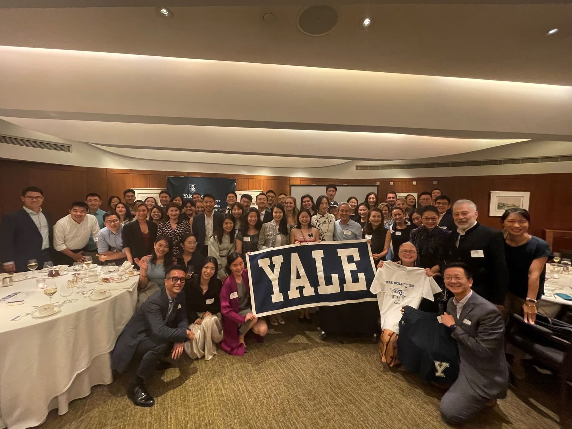 Club members gathered around a Yale banner at the Thanksgiving dinner