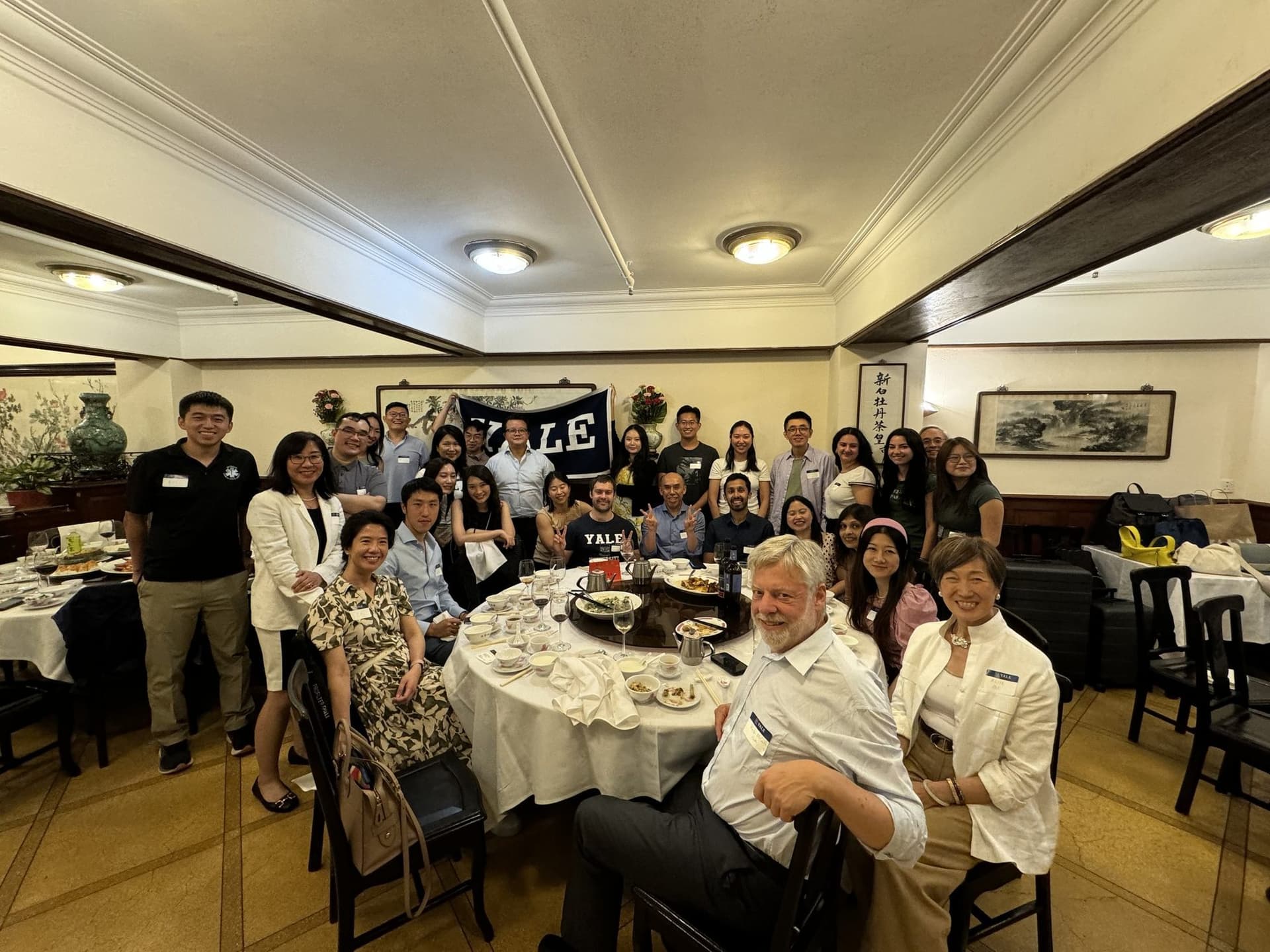 Club members gathered under a Yale banner for a Fourth of July dinner