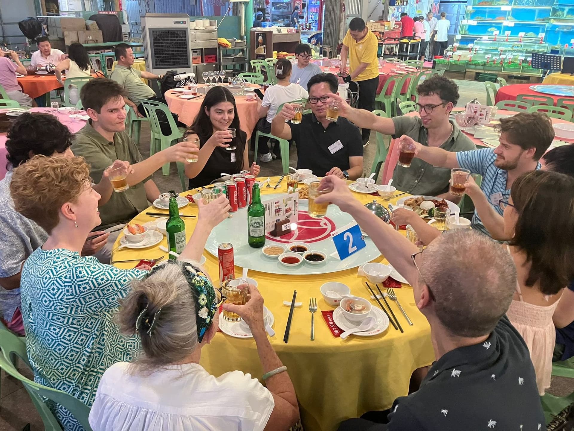 Yale alumni and Yale-China fellows raising a toast around a table on Lamma Island