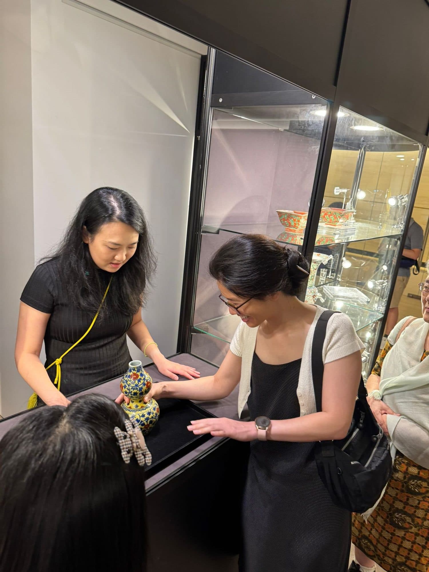 Members handling a ceramic vessel during a private viewing at Sotheby's Hong Kong