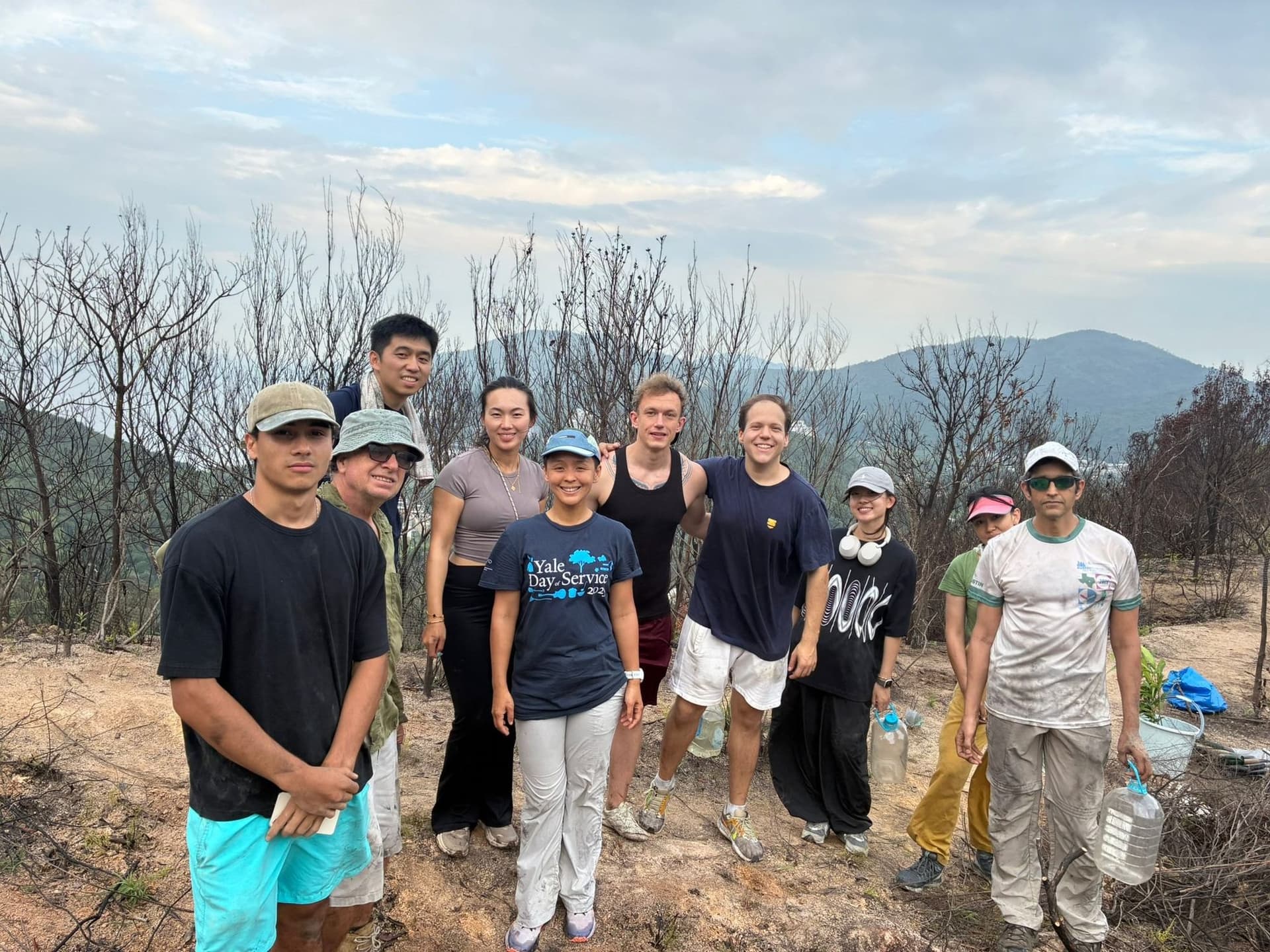 Volunteers in Yale Day of Service shirts standing on a replanted Lantau hillside